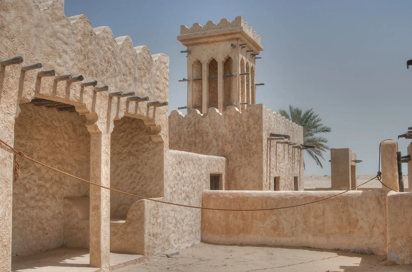 معماری سنتی کویری با دیوارهای ضخیم و بادگیر