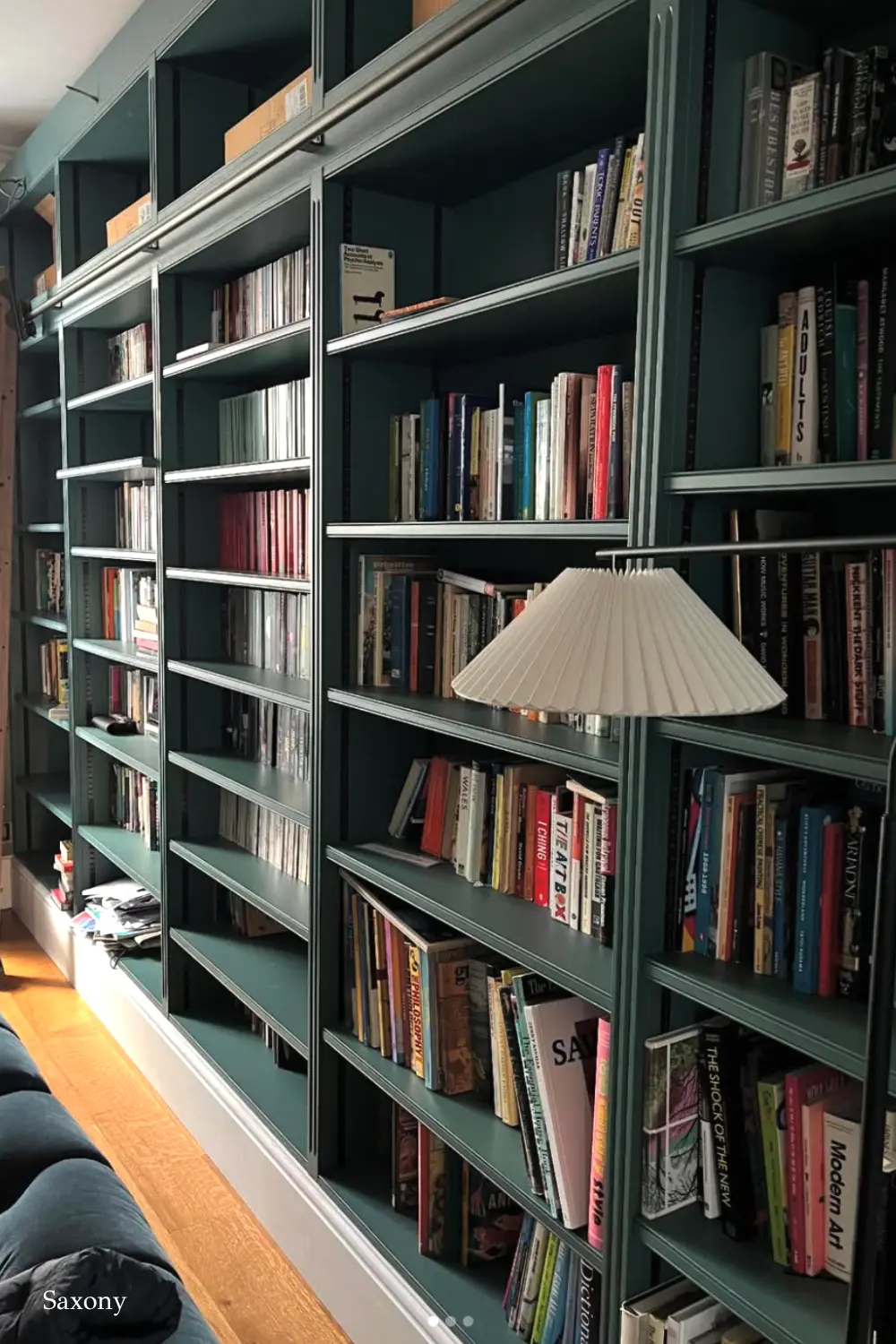 کتابخانه دیواری با طراحی شیشه‌ای و فلزی در دکوراسیون مدرن
