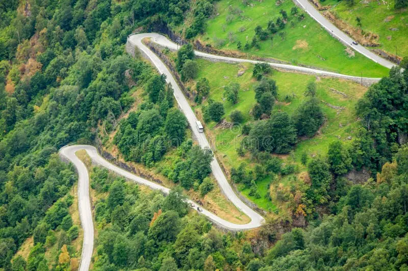 نماهای هوایی از جاده‌ای مارپیچ با شیب تند در نزدیکی گیرانگر، نروژ، با اتوبوس بزرگ