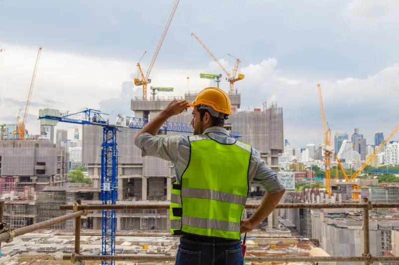 همکاری تیمی در یک پروژه ساختمانی با حضور مهندسان، معماران و کارگران