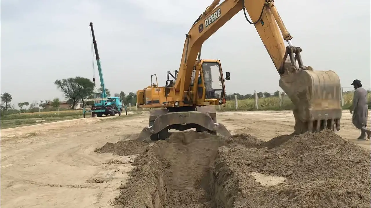 اپراتور بیل مکانیکی در حال استفاده از دستگاه مدرن با سیستم‌های هوشمند